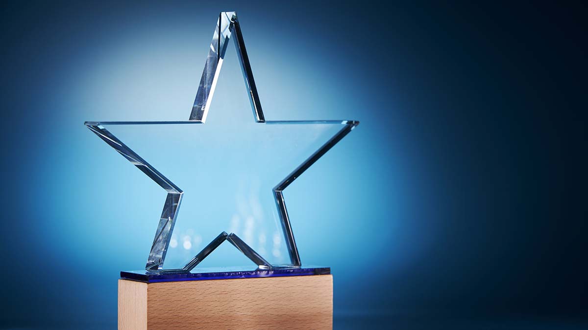 Recipients - Crystal star shape trophy against blue background