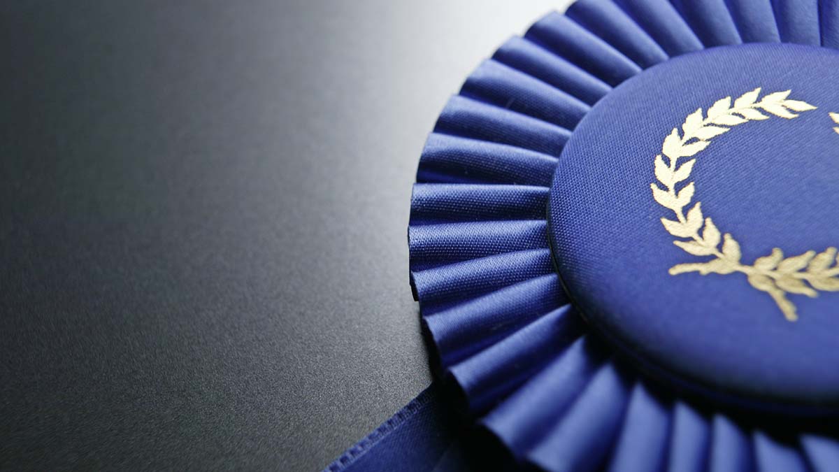 Scholarship Recipients | Blue ribbon rosette on dark gray graduated background