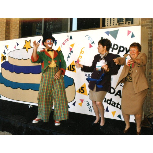 Clown on stage with two women laughing